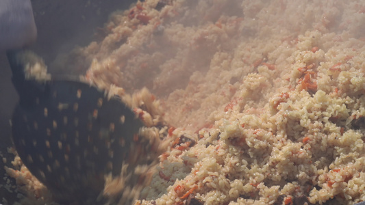 在大锅里煮肉饭混合米饭拿着厨房勺子的肉亚洲传统烹饪视频