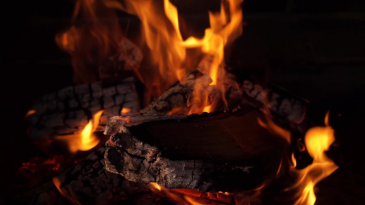 在夜间营火中烧焦燃烧的橡木木木柴红热火焰和喷雾视频