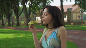 女孩坐在公园的地上吃个三明治吃个三明治13秒视频