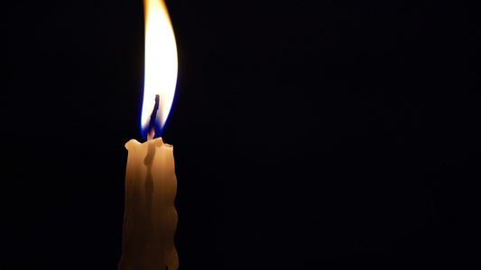 夜幕黑暗中点燃蜡烛在黑色背景上点燃蜡烛的特拍片段视频