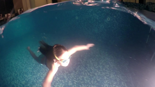 小女孩在室内暗泳池水下游泳视频