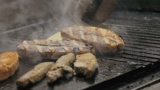 厨师烹饪肉和鱼在烤架上视频