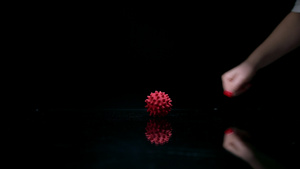 女手在镜面上旋转纹红色圆球8秒视频