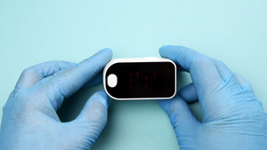 一名身戴蓝色乳胶手套的医生拿着电子脉冲血氧计13秒视频