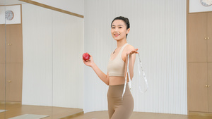 运动美女拿着苹果和软尺11秒视频