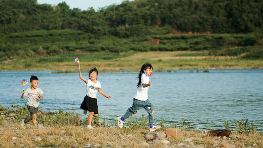 4k实拍三个小朋友小溪边风车奔跑玩耍升格视频视频