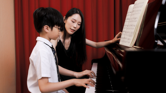 音乐教师教儿童弹奏钢琴视频