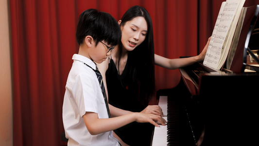 音乐教师教儿童弹奏钢琴视频