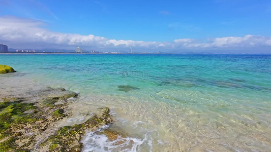 阳光下的海南三亚海棠湾蜈支洲岛海岸线上礁石沙滩海浪玻璃海浪花微距慢镜视频