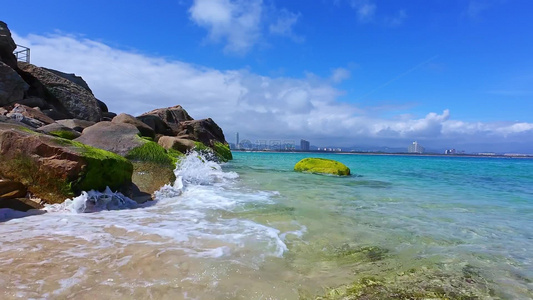 阳光下的海南三亚海棠湾蜈支洲岛海岸线上礁石沙滩海浪玻璃海浪花微距慢镜视频