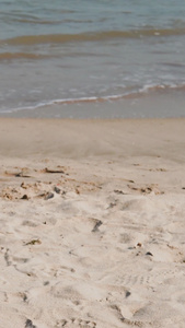 沙滩上手拿太阳帽子特写海浪涨潮视频