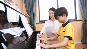 音乐家教指导男孩弹奏钢琴12秒视频