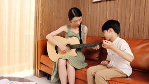 音乐家教指导男孩弹吉他16秒视频