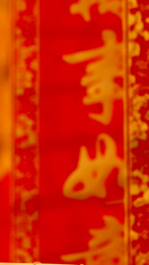 红色喜庆背景前悬挂红包福字礼盒从上往下实拍静物视频牛年大吉视频