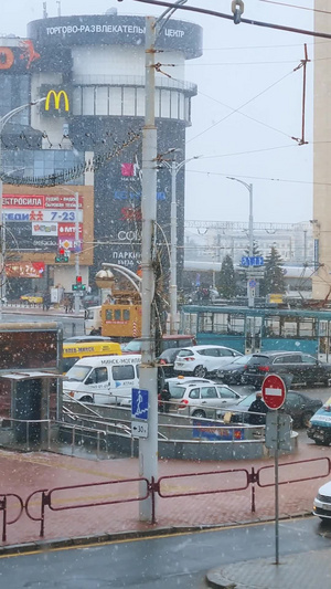 冬天城市街头初雪路上行驶的轨道列车飘落雪花12秒视频