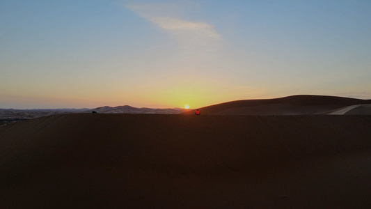 航拍沙漠日落下的人影[白影]视频