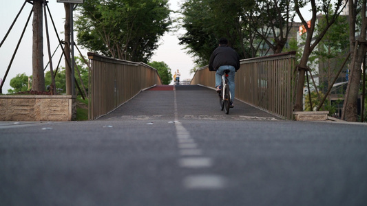 公园桥上骑自行车的人[桥旁]视频