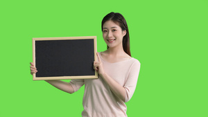 4k穿休闲服的女生手拿黑板展示动作绿幕抠像视频6秒视频