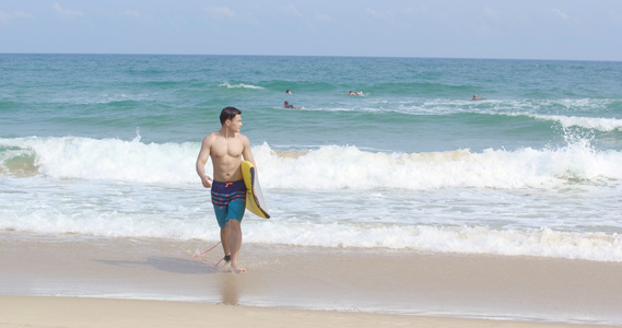 8K海边抱着冲浪板的男青年视频