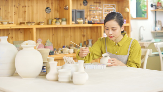 4k陶器陶瓷DIY店里给陶器上色的女生视频