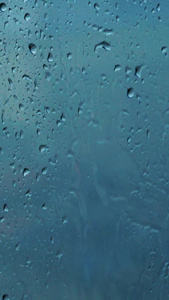 窗外雨滴下雨天梅雨季节玻璃窗上的水滴水珠视频
