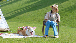 年轻女孩和狗在户外郊游看书24秒视频