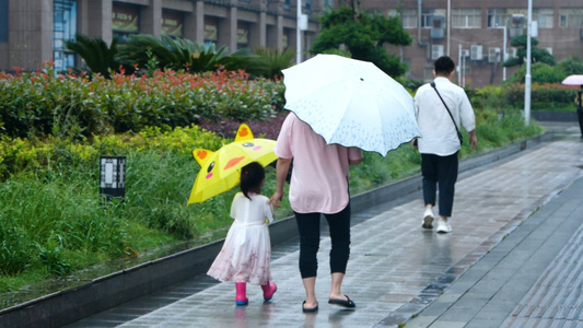 梅雨季升格雨中撑伞的母女家长接送孩子放学亲子时光母女背影视频