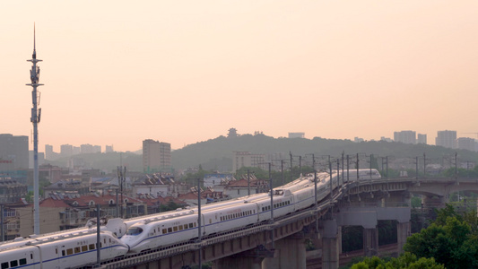 日出阳光下在城市中穿行的高铁火车视频