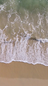 航拍海边沙滩上与海浪玩耍的少女素材海景素材视频