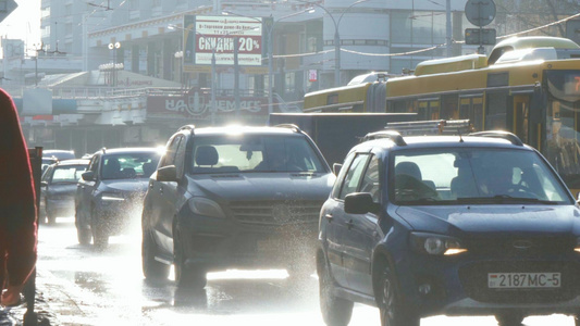 雨后夕阳下拥堵的城市道路车流溅起水花视频