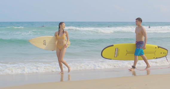 8K海边拿着冲浪板的泳装情侣视频