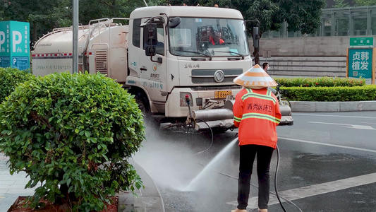 环卫工人清扫冲洗街道洒水车作业清洁视频
