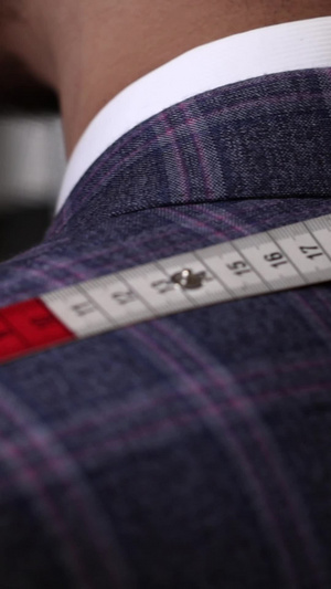 用皮尺测量顾客肩宽的特写镜头服装店11秒视频