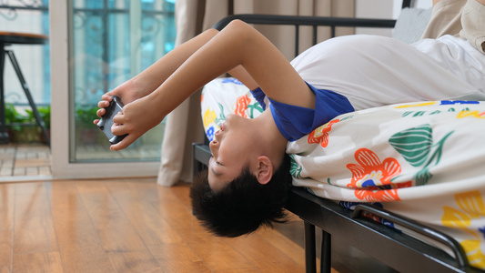 小男孩倒立在沙发上玩游戏机视频