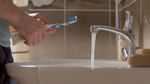 年轻人挤着牙膏在刷子上28秒视频