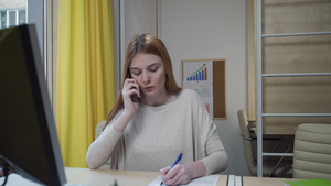 忙碌的女人在电话上说话在纸页上做笔记14秒视频