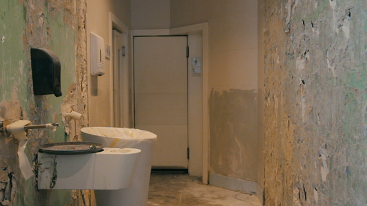 公共洗手间在混乱的阶段进行翻修,拆除墙壁和地板上的瓷砖隔视频