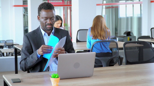 非裔美国人经理拿着文件夹在初创公司的开放空间办公室工作人员工作视频