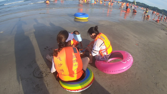 海滩上玩沙的游客风光视频