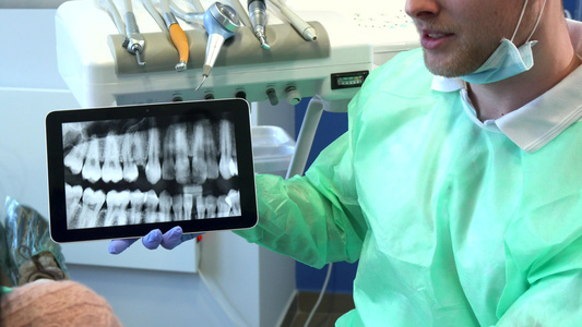 牙医在平板电脑上移动X光图像视频