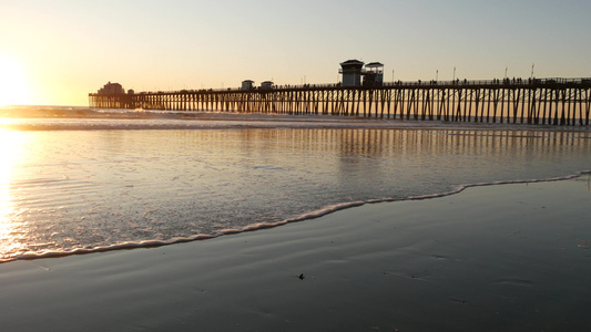 桩上的木码头，日落时的剪影，美国加利福尼亚州，海滨。日落时阳光明媚的海浪视频