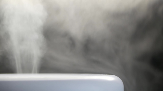 超声波加湿器的白色蒸汽。来自扩散器的蒸汽，用于空气保湿。循环播放无尽的烟雾视频以检测家里的湿度。空气的保湿剂和视频
