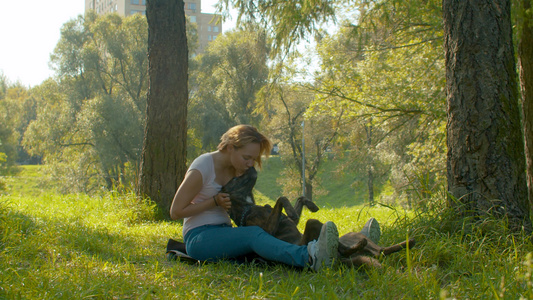 美丽的女人和她的狗在公园里视频