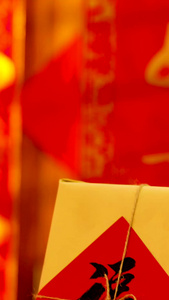 红色喜庆背景前悬挂红包福字礼盒实拍静物视频传统节日视频