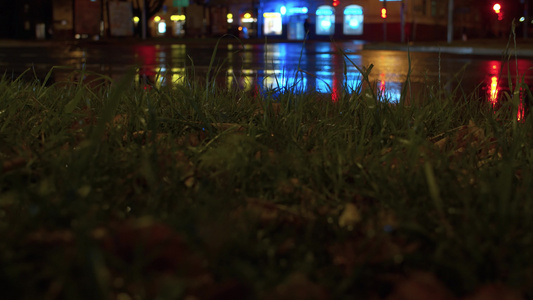 夜间交通灯bokeh雨滴在草地上视频