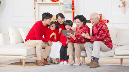 红火过年春节一家人在沙发上和远方亲戚视频通话视频