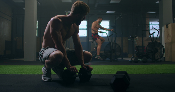 一名男性健美运动员在经过循环性心操锻炼后坐在健身房视频