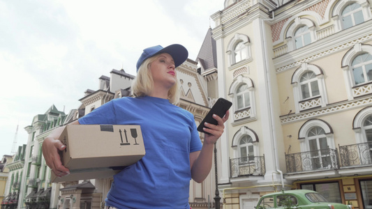 使用智能电话在线地图装有包裹箱的送货妇女视频
