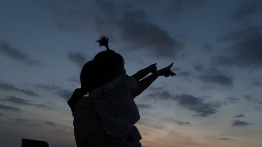 4K实拍夕阳下母女手指向天空的温馨可爱剪影画面视频