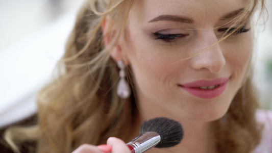与美丽的年轻女性一起工作的专业化妆师视频